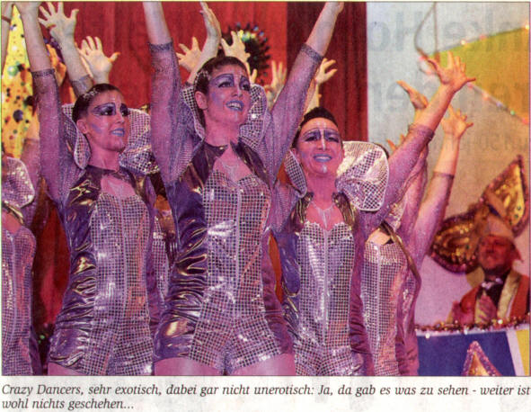 Tänzerinnen der „Crazy Dancers“ in silbern glitzernden Kostümen mit erhobenen Armen auf der Bühne, Zeitungsausschnitt