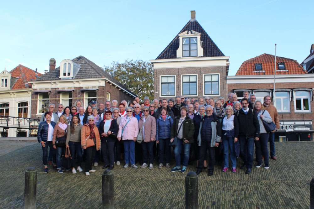 Die Mainflinger Reisegruppe beim Gruppenfoto vor holländischen Backsteinhäusern mit Spitz- und Mansardgiebeln
