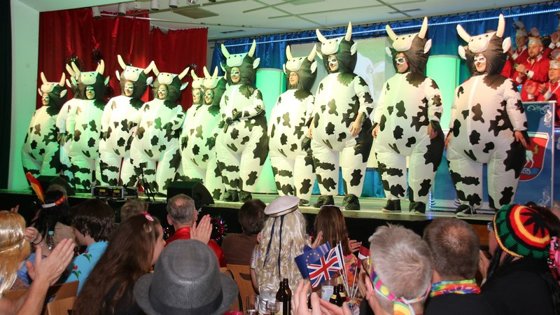 Die Tanzgruppe „Back to Stage“ in überdimensionalen aufblasbaren Kuhkostümen auf der Bühne, davor das applaudierende Publikum