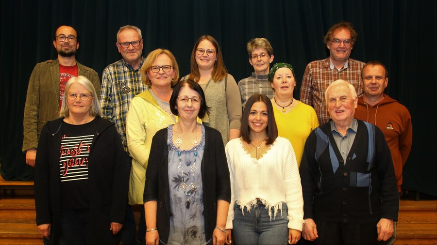 Gruppenbild des bestätigten Vorstands der Sängervereinigung vor dem Bühnenvorhang im Bürgerhaussaal